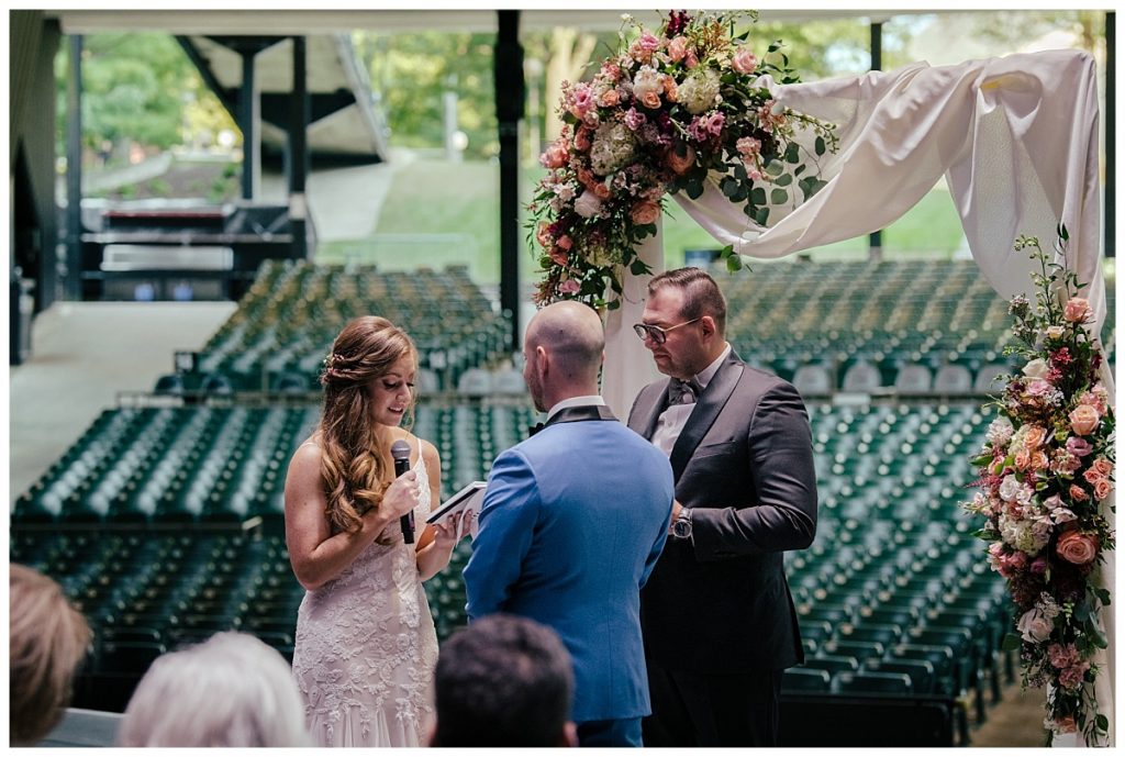 A Saratoga Springs SPAC Wedding 31 bride saying her vows on the stage at SPAC