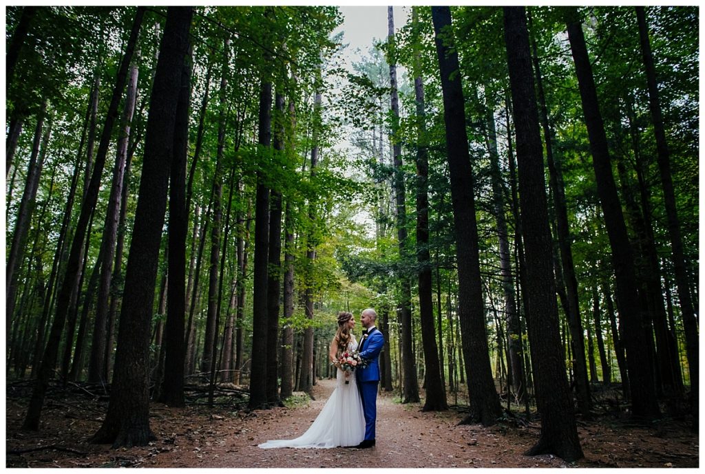 A Saratoga Springs SPAC Wedding 57 spac wedding day portrait of a bride and groom in a pine forrest