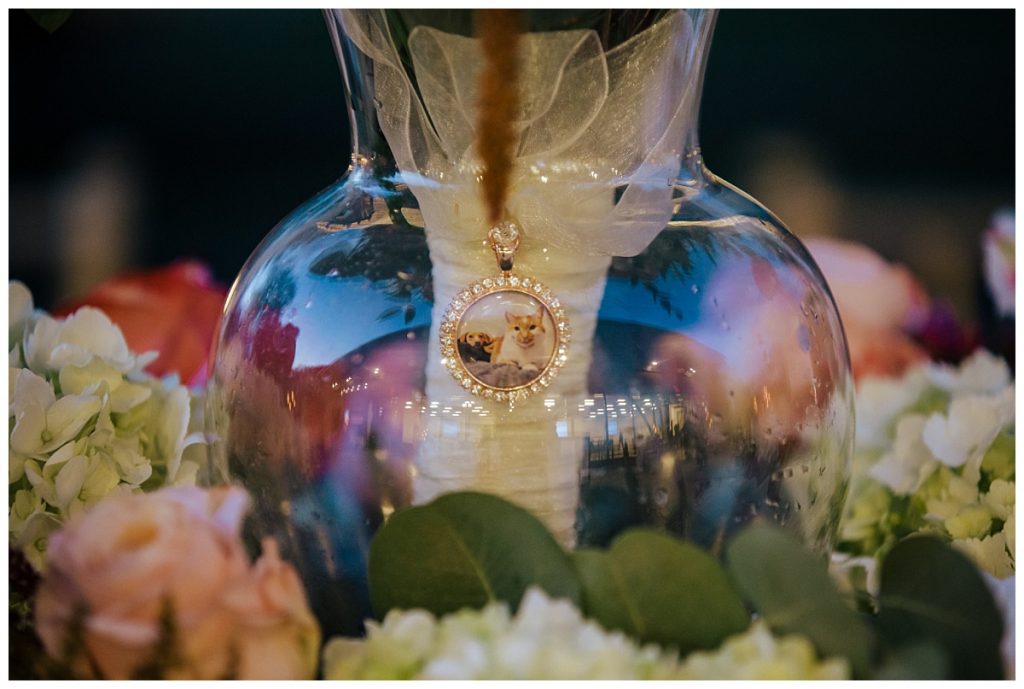 A Saratoga Springs SPAC Wedding 59 detail of a bridal bouquet locket that features the bride and groom's pets